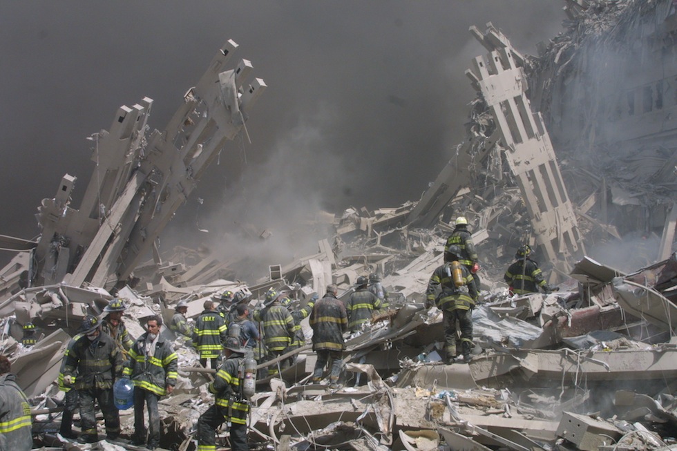 Firefighters walk through the rubble in the aftermath of the September 11 attacks.(AP Photo/Shawn Baldwin)