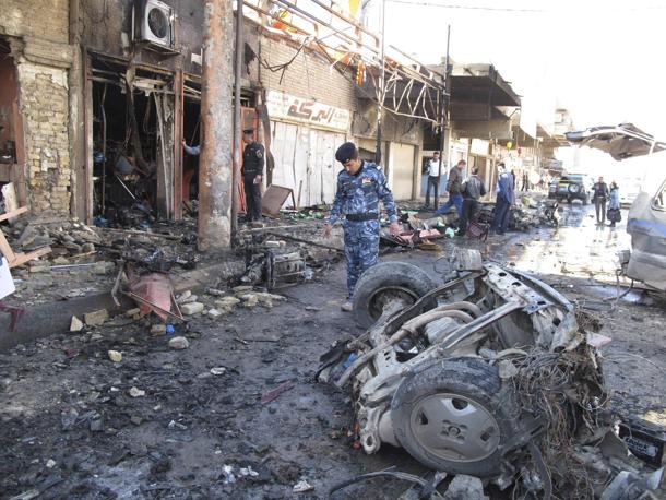 Iraqi security forces inspect the site of a bomb attack in Hilla, 100 km (60 miles) south of Baghdad, March 20, 2012. Car and roadside bombs exploded in cities and towns across Iraq on Tuesday, killing at least 29 people, police and hospital sources said, extending a spate of violence ahead of next week's Arab League summit in Baghdad.  REUTERS/Habib (IRAQ - Tags: CONFLICT POLITICS CIVIL UNREST)