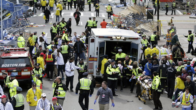 Medical workers aid injured people at the finish line of the 2013 Boston Marathon following an explosion in Boston, Monday, April 15, 2013.  Two explosions shattered the euphoria of the Boston Marathon finish line on Monday, sending authorities out on the course to carry off the injured while the stragglers were rerouted away from the smoking site of the blasts. (AP Photo/Charles Krupa)
