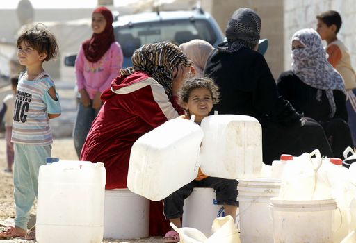 Syrian refugees wait to fill up plastic water containers at the Al-Zaatari refugee camp near the Jordanian city of Mafraq, some 8-kilometres from the Syrian border, on July 26, 2013. The northern Jordanian Zaatari refugee camp is home to 115,000 Syrians AFP PHOTO/KHALIL MAZRAAWI