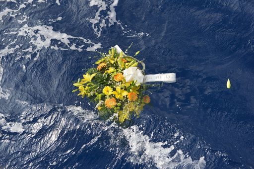 A picture taken on October 5, 2013 shows a bunch of flowers reading "Dead at sea" floating in the sea near the Lampedusa harbour after a boat with migrants sank killing more than a hundred of people. Italy mourned today the 300 African asylum-seekers feared dead in the worst ever Mediterranean refugee disaster, as the government appealed for Europe to stem the influx of migrants. Italian emergency services hoped to resume the search for bodies on October 5, 2013 despite rough seas after the accident, in which 111 African asylum-seekers are confirmed dead and around 200 more are still missing. AFP PHOTO / ALBERTO PIZZOLI