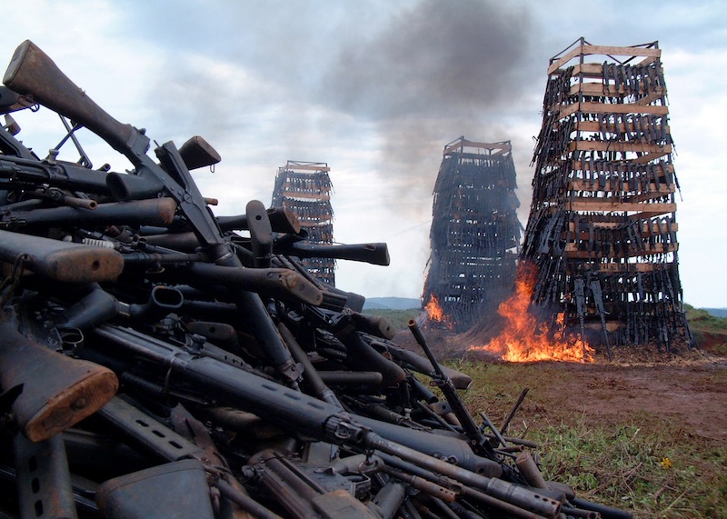 Rwandan weapons burn near the Rwandan capital of Kigali April 14, 2005. Rwanda burnt a heap of guns, mortar tubes and ammunition on Thursday to show its commitment to a regional plan to staunch the flow of arms fuelling conflicts in Africa, officials said on Thursday. Rwanda was among 11 countries from central and northeast Africa which signed a pact to combat the illicit manufacture, trafficking and use of small arms and light weapons in the region, torn by numerous conflicts.    REUTERS/Themistocles Hakizimana