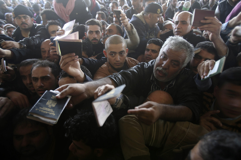 Palestinians, hoping to cross into Egypt, present their passports at the Rafah crossing between Egypt and the southern Gaza Strip December 21, 2014. Egypt opened the Rafah border crossing on Sunday allowing Palestinians from Gaza Strip to travel in and out for the first time since the passage was closed on October 25, Palestinian and Egyptian officials said. The Rafah crossing was shut on Oct. 25 after Islamist militants in Egypt's adjacent Sinai region killed 33 members of the security forces in some of the worst anti-state violence since Islamist president Mohamed Mursi was toppled in July 2013.  
REUTERS/Ibraheem Abu Mustafa (GAZA - Tags: POLITICS CIVIL UNREST SOCIETY IMMIGRATION) - RTR4ITR4