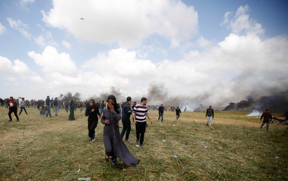 Una donna si allontana dai gas lacrimogeni. (AP Photo/Adel Hana)