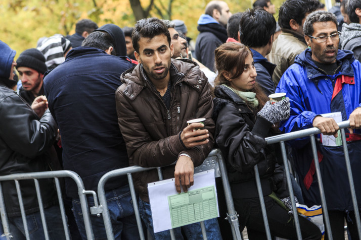 BERLIN, GERMANY - OCTOBER 21: A man holds a form while like other migrants seeking refugee status wait to register outside the Central Registration Office for Asylum Seekers (Zentrale Aufnahmestelle fuer Asylbewerber, or ZAA) of the State Office for Health and Social Services (Landesamt fuer Gesundheit und Soziales, or LAGeSo) on October 21, 2015 in Berlin, Germany. Berlin recently expanded its registration system for asylum-applicants with a second center. Once initially registered at LAGeSO, applicants are taken by bus to the new center where they can apply for refugee status and receive job counseling all within the same day in a process that was previously more arduous. The city is struggling to process large numbers of applicants who often wait for days on end outside the main LAGeSO building in conditions that have prompted protests by volunteer aid groups.  (Photo by Carsten Koall/Getty Images)