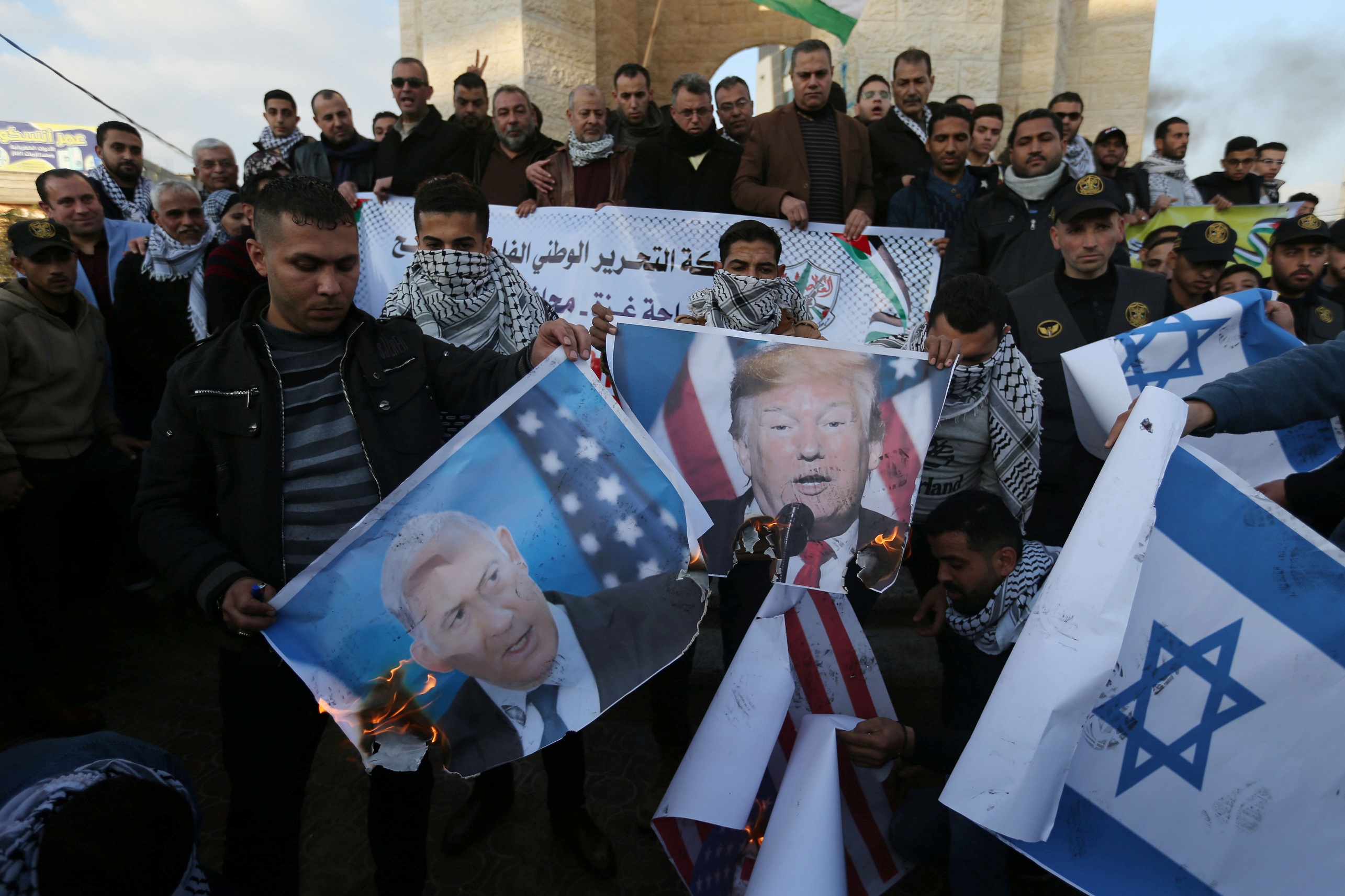 Palestinian demonstrators burn pictures depicting U.S. President Donald Trump and Israeli Prime Minister Benjamin Netanyahu, and repsentations of U.S and Israeli flags during a protest against the U.S. President Donald Trump's Middle East peace plan, in the southern Gaza Strip January 29, 2020. REUTERS/Ibraheem Abu Mustafa