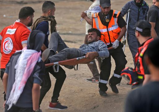 Palestinians carry a demonstrator injured during clashes with Israeli forces near the border between the Gaza strip and Israel east of Gaza City on May 14, 2018, during a demonstration on the day of the US embassy move to Jerusalem.
The US moves its embassy in Israel to Jerusalem later Monday after months of global outcry, Palestinian anger and exuberant praise from Israelis over President Donald Trump's decision tossing aside decades of precedent. There are concerns that the Gaza protests less than 100 kilometres (60 miles) away will turn deadly if Palestinians attempt to damage or cross the fence with Israeli snipers positioned on the other side. / AFP PHOTO / MAHMUD HAMS