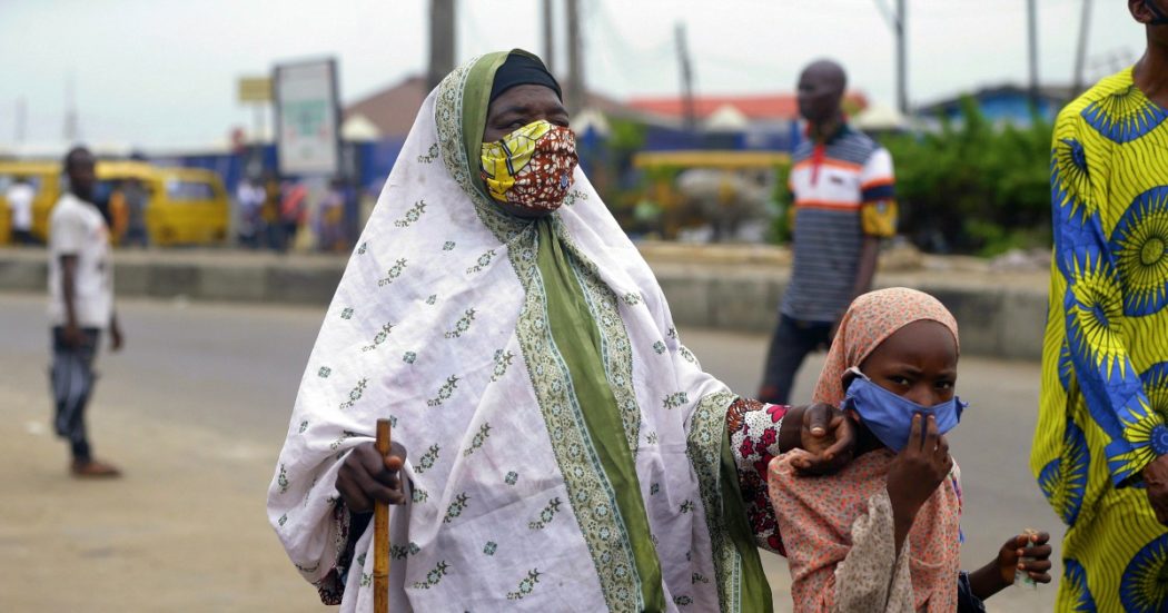A beggar wearing a face mask walks on the street Lagos Nigeria, Monday May 4, 2020. Though Nigeria begun a phased easing of its strict lockdown measures on Monday, its confirmed cases of coronavirus continue to increase. (AP Photo/Sunday Alamba)